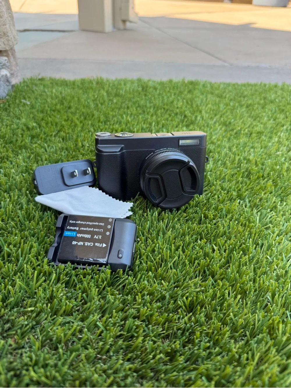 Compact Black Digital Camera with Accessories and Lens Cap